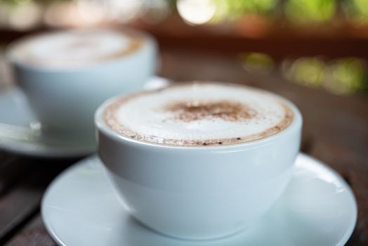 Coffee drink in the white coffee cup on wood table for serve to customers at coffee shop cafe or restaurant