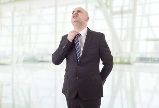 worried businessman in a suit looking up, at the office