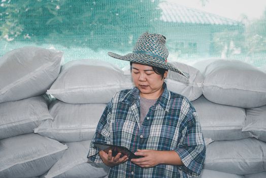 Asian woman smart farmer agriculturist happy at a Fertilizer composting plant with Organic Fertilizer, Compost (Aerobic Microorganisms) from animal waste for use in the organic agriculture industry