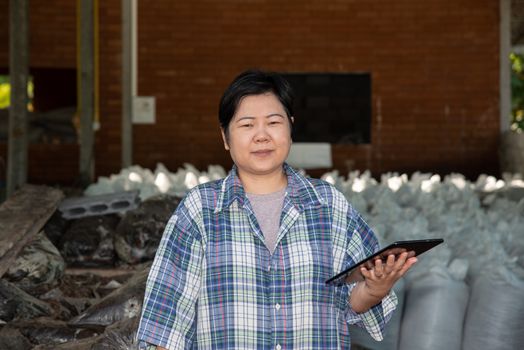 Asian woman smart farmer agriculturist happy at a Fertilizer composting plant with Organic Fertilizer, Compost (Aerobic Microorganisms) from animal waste for use in the organic agriculture industry