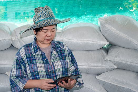 Asian woman smart farmer agriculturist happy at a Fertilizer composting plant with Organic Fertilizer, Compost (Aerobic Microorganisms) from animal waste for use in the organic agriculture industry