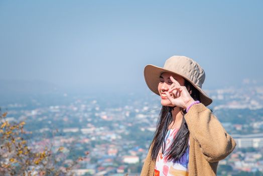 Asian pretty cute woman with hat relax at seaside city landscape viewpoint on mountain with happy and freedom emotion in concept travel, vacation, leisure in life