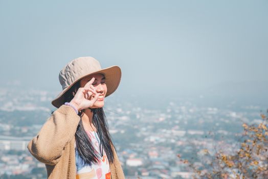 Asian pretty cute woman with hat relax at seaside city landscape viewpoint on mountain with happy and freedom emotion in concept travel, vacation, leisure in life