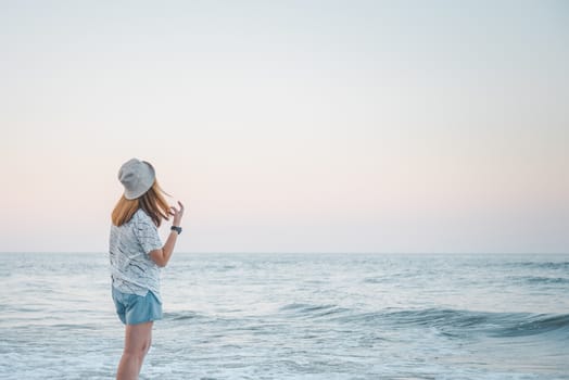 Asian pretty cute woman relax at sea beach with happy and freedom emotion in concept travel, vacation, leisure, fun in life