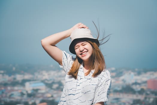 Asian pretty woman with hair blown relax at sea viewpoint with loneliness and lonely emotion in concept travel, vacation, leisure in life