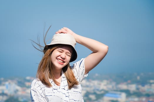 Asian pretty woman with hair blown relax at sea viewpoint with loneliness and lonely emotion in concept travel, vacation, leisure in life