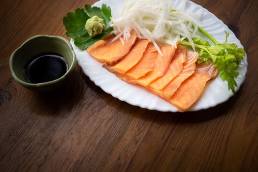 Japanese food delicacy consisting sashimi salmon of very fresh raw salmon fish sliced into thin pieces serving with radish sliced in japan restaurant