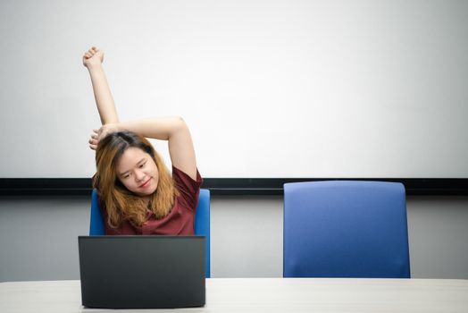 Asian woman is student,businesswoman working by computer notebook, laptop in office meeting room with whiteboard background with relax, concentrate emotion in concept working woman,success in life