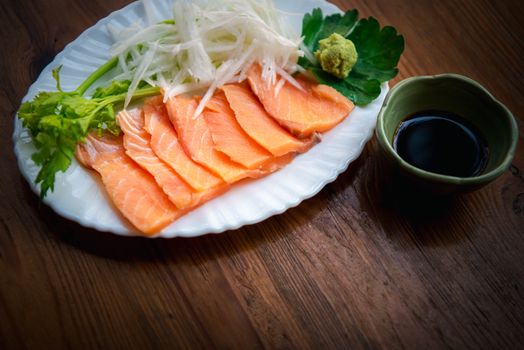 Japanese food delicacy consisting sashimi salmon of very fresh raw salmon fish sliced into thin pieces serving with radish sliced in japan restaurant