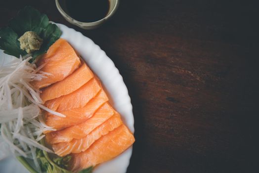 Japanese food delicacy consisting sashimi salmon of very fresh raw salmon fish sliced into thin pieces serving with radish sliced in japan restaurant