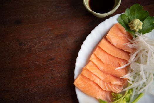 Japanese food delicacy consisting sashimi salmon of very fresh raw salmon fish sliced into thin pieces serving with radish sliced in japan restaurant