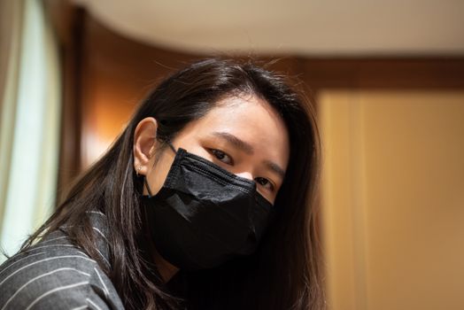 Asian pretty woman wearing mask respiratory protection mask against epidemic flu covid19 or corona virus influenza in office with fear emotion in concept illness, outbreak, healthcare in life