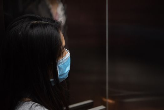 Asian pretty woman wearing mask respiratory protection mask against epidemic flu covid19 or corona virus from wuhan in office with fear emotion in concept illness, outbreak, healthcare in life