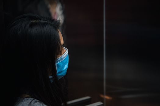 Asian pretty woman wearing mask respiratory protection mask against epidemic flu covid19 or corona virus from wuhan in office with fear emotion in concept illness, outbreak, healthcare in life