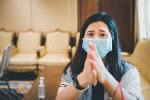 Asian woman wearing mask and alcohol antibacterial hand gel respiratory protection mask against epidemic flu covid19 or corona virus with fear emotion in concept illness, outbreak, healthcare in life