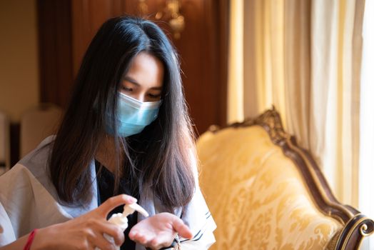 Asian woman wearing mask and alcohol antibacterial hand gel respiratory protection mask against epidemic flu covid19 or corona virus with fear emotion in concept illness, outbreak, healthcare in life