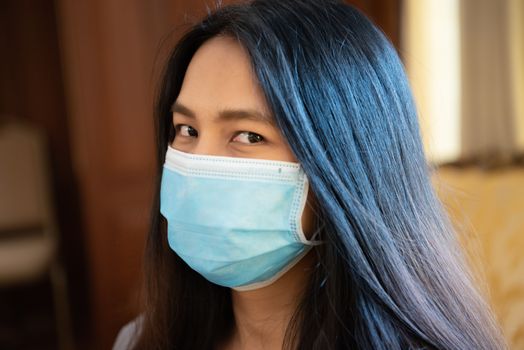 Asian pretty woman wearing mask respiratory protection mask against epidemic flu covid19 or corona virus from wuhan in office with fear emotion in concept illness, outbreak, healthcare in life