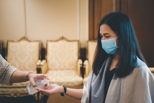 Asian woman wearing mask and alcohol antibacterial hand gel respiratory protection mask against epidemic flu covid19 or corona virus with fear emotion in concept illness, outbreak, healthcare in life