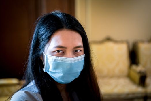 Asian pretty woman wearing mask respiratory protection mask against epidemic flu covid19 or corona virus from wuhan in office with fear emotion in concept illness, outbreak, healthcare in life