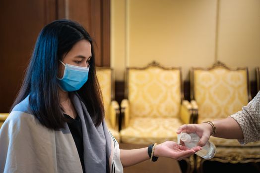 Asian woman wearing mask and alcohol antibacterial hand gel respiratory protection mask against epidemic flu covid19 or corona virus with fear emotion in concept illness, outbreak, healthcare in life