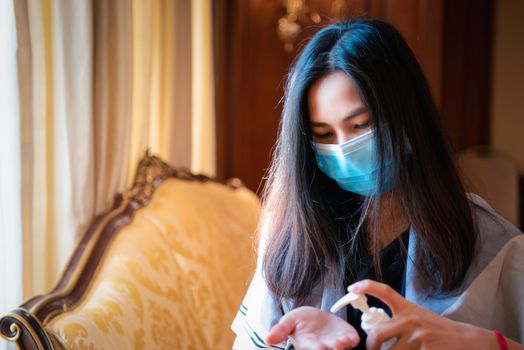 Asian woman wearing mask and alcohol antibacterial hand gel respiratory protection mask against epidemic flu covid19 or corona virus with fear emotion in concept illness, outbreak, healthcare in life