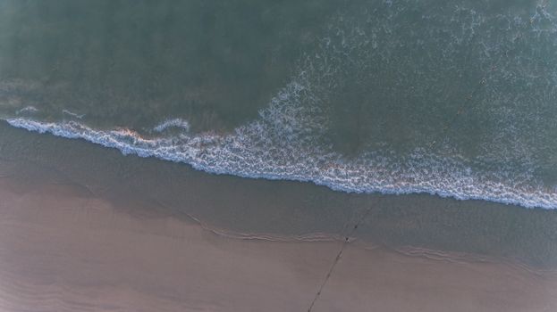 Aerial sea wave on the beach over sunset 