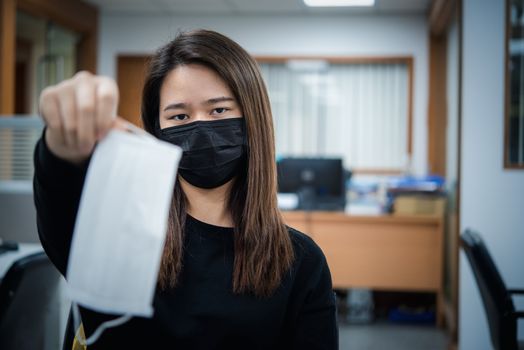 Asian pretty woman wearing mask respiratory protection mask against epidemic flu covid19 or corona virus from wuhan in office with fear emotion in concept illness, outbreak, healthcare in life