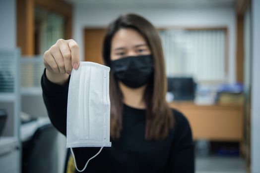 Asian pretty woman wearing mask respiratory protection mask against epidemic flu covid19 or corona virus from wuhan in office with fear emotion in concept illness, outbreak, healthcare in life