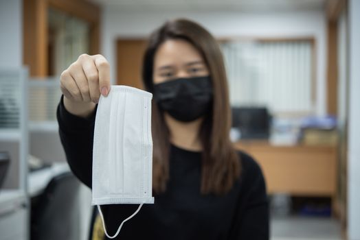 Asian pretty woman wearing mask respiratory protection mask against epidemic flu covid19 or corona virus from wuhan in office with fear emotion in concept illness, outbreak, healthcare in life