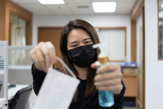 Asian woman wearing mask and alcohol antibacterial hand gel respiratory protection mask against epidemic flu covid19 or corona virus with fear emotion in concept illness, outbreak, healthcare in life