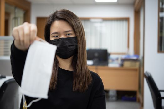 Asian pretty woman wearing mask respiratory protection mask against epidemic flu covid19 or corona virus from wuhan in office with fear emotion in concept illness, outbreak, healthcare in life