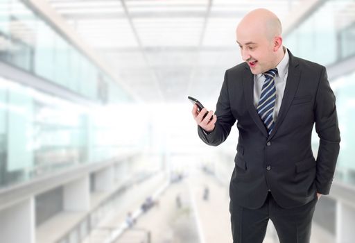 Silly businessman surprised with a cellphone at the office