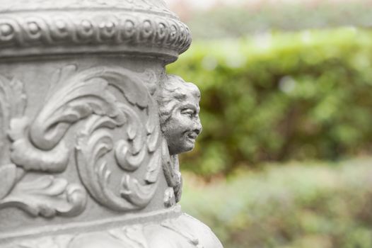 Fragment Of Decorative Head Column Sculpture On A Blurred Background