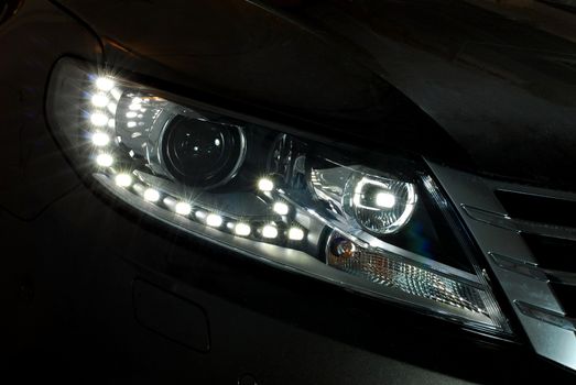 Closeup photo of a black car's headlight