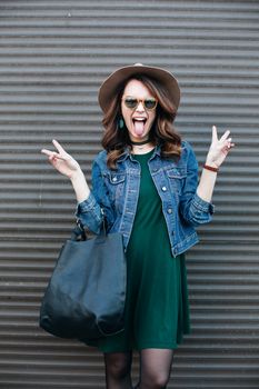 Romantic and beautiful brunette girl in brown hat lokking at camera and posing at street. Attractive woman with wavy hair, perfect make up, walking after beauty salon. Street fashion.