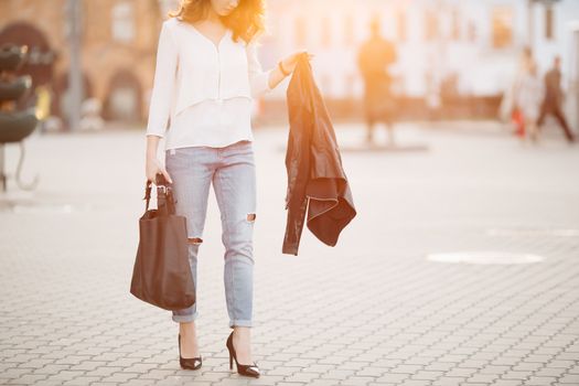 Beautiful positivity brunette woman in hat, white blouse, jeans walking at sunset in city, after shopping and beauty salon. Smiling fashionable girl stylish wearing posing at camera. Hipster look.