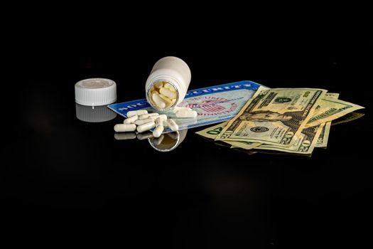 A bottle of pills on top of a blank social security card surrounded by American money