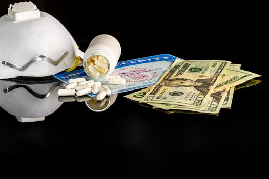 A bottle of pills on top of a blank social security card surrounded by American money