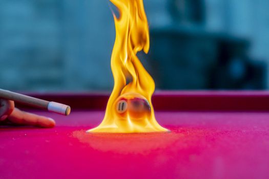 Billiard balls are photographed on fire while sitting outdoors in an open environment