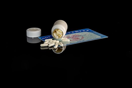 A bottle of pills on top of a blank social security card surrounded by American money