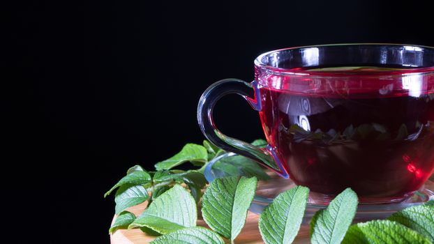 Tea time: cup of tea. Creative layout made of cup of hibiscus tea and tea leafs. Red tea, carcade, karkade, rooibos. Oriental, cozy, ceremony, tradition, japanese, leafy, hygge, autumn, 5 o'clock