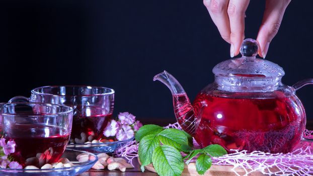 Red tea, hibiscus, karkade, Rooibos. A woman makes tea. Ceremony, afternoon tea, Breakfast. Tea time, carcade. Oriental, cozy, tradition, japanese, leafy, hygge, autumn, 5 o'clock, leaves, mug, pour