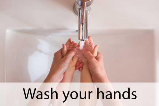 Mother and daughter washing hands with water and soap