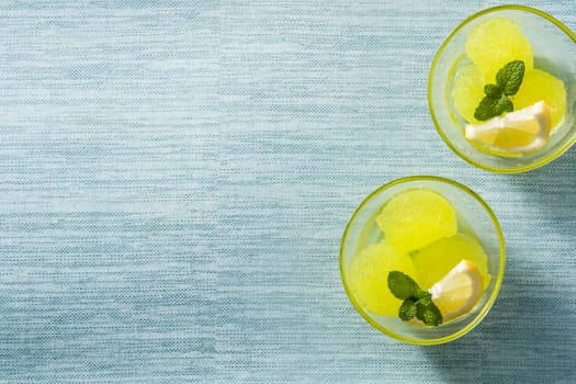 Lemon sorbet with mint in glasses on blue background