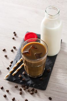 Iced coffee or caffe latte in a tall glass on wooden table