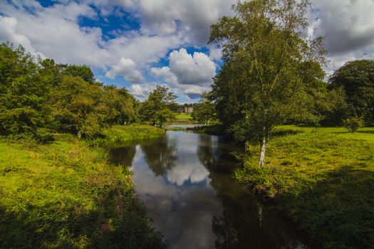 The English countryside during summer of a river and the surrounding reflections