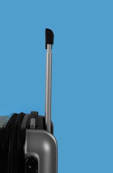 Travel bag on blue background.. Silver suitcase  with holding on blue background with copy space.