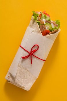 Doner kebab or shawarma sandwich isolated on yellow background