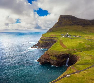 Aerial view of the Gasadalur village and its iconic waterfall in Faroe Islands, Denmark