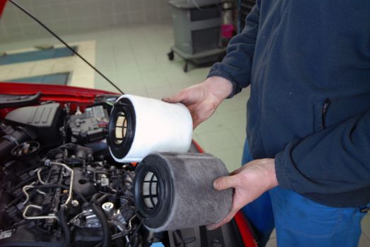 Repairman holding an old and a new air filter